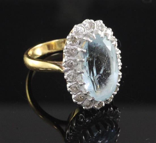 An 18ct gold aquamarine and diamond oval cluster ring, size M.